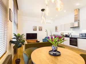 eine Küche und ein Wohnzimmer mit einem Tisch und einem Sofa in der Unterkunft Be London - Covent Garden Apartments in London