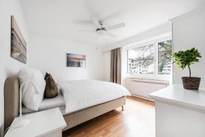 ein weißes Schlafzimmer mit einem Bett und einem Fenster in der Unterkunft Cooldis 13 (Gratis Parken, Free Parking) in Kreuzlingen