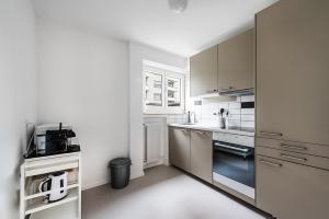 cocina con armarios blancos y encimera en Cooldis 13 (Gratis Parken, Free Parking), en Kreuzlingen