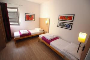 a room with two beds and a window at Villa Deny Mostar in Mostar