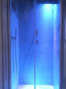 una doccia con porta in vetro in bagno di Il Paradosso Suite a Viterbo