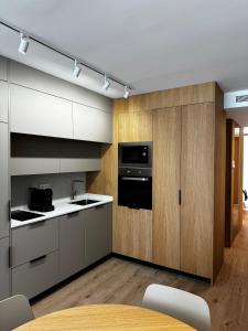 a kitchen with white cabinets and a black appliance at Reyes Católicos Premium Beach, Playa Urbanova, Alicante in Alicante