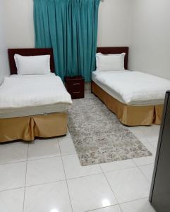 2 letti posti in una stanza con tappeto di جودي للغرف الفندقية المتميزة a Al Khobar