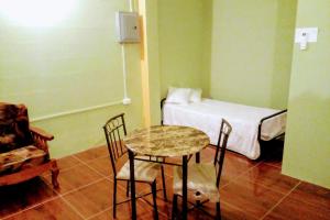 Cette chambre comprend une table, des chaises et un lit. dans l'établissement OverNite Comfort, à Saint Augustine