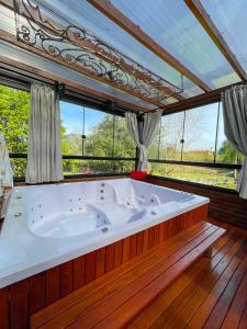 São Valentim do Sul的住宿－Cabana Aconchego do Recanto，带窗户的客房内的大浴缸