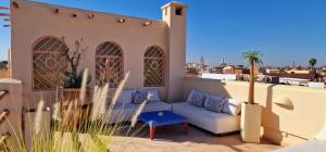 un sofá sentado en el balcón de una casa en Riad Dar Tayib, en Marrakech