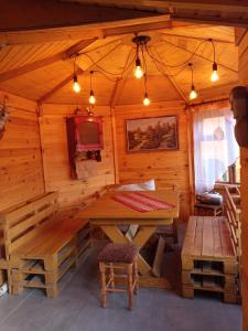 ein Holzzimmer mit einem Tisch und einer Bank in der Unterkunft NOCLEGI KAMEX domek 2-osobowy in Olsztyn