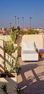 a white couch sitting on a patio with plants at Riad de Vincent in Marrakesh