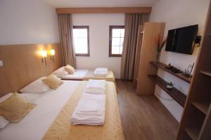 a hotel room with two beds and a flat screen tv at Villa Deny Mostar in Mostar