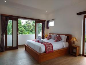 Un dormitorio con una cama y una ventana grande. en Prema Shiva Suites and Villas by EPS, en Ubud