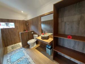 een badkamer met een toilet, een wastafel en een spiegel bij Prema Shiva Suites and Villas by EPS in Ubud