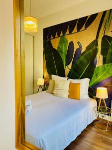 1 dormitorio con cama blanca y espejo grande en ''Chichi 2'' Chez Paule Superbe appartement en plein coeur de Sète, en Sète