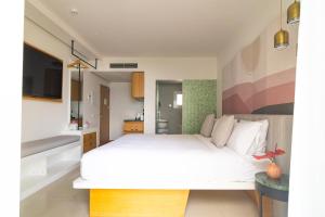a bedroom with a white bed and a tv at Boutique Apartments Marsol Ibiza in Santa Eularia des Riu
