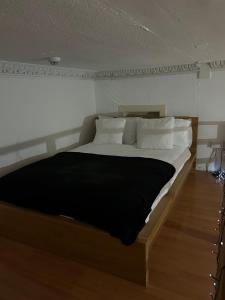 1 dormitorio con 1 cama con sábanas negras y almohadas blancas en Alexander Greek Thomson Apartment, en Glasgow