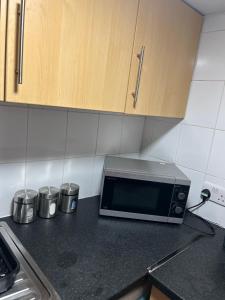 a kitchen counter with a microwave on a counter top at Alexander Greek Thomson Apartment in Glasgow