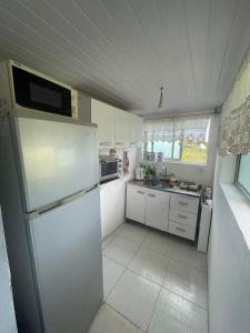 uma cozinha branca com um frigorífico e um lavatório em Cabaña de playa em Balneario Buenos Aires