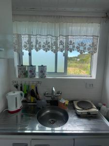 um balcão de cozinha com um lavatório e uma janela em Cabaña de playa em Balneario Buenos Aires