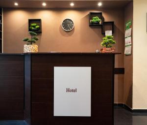 a hotel counter with potted plants and a clock at Hotel Stadion Stadt in Hamburg