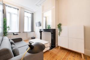 een woonkamer met een bank en een tafel bij Vieux Lille - Nice studio with terrace in Lille