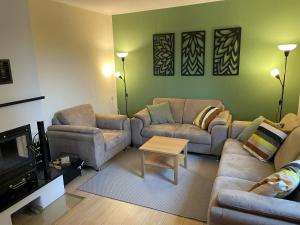 a living room with two couches and a coffee table at Ferienhaus zum Glück, mit Pool und Kamin in Gerswalde