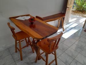 una mesa de madera y sillas con una planta en Au paradis des Lapas, en Cabuya