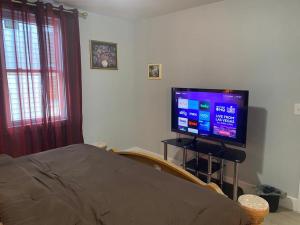 1 dormitorio con 1 cama y TV en un soporte en King Suite 8Mins to Newark Airport, en Newark
