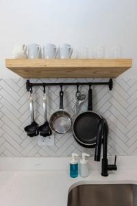 a shelf above a kitchen sink with pots and pans at Beachwalk #5 8 Mins to Beach in Virginia Beach