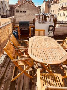 uma mesa de madeira e cadeiras sentadas numa varanda em Sublime Rooftop Cinq-Avenues Longchamp em Marselha