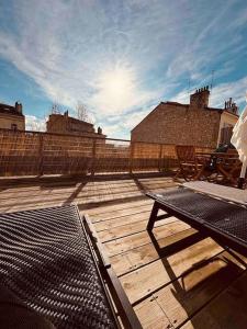 een houten terras met een tafel en een hek bij Sublime Rooftop Cinq-Avenues Longchamp in Marseille