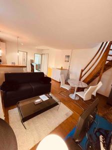 uma sala de estar com um sofá preto e cadeiras brancas em Sublime Rooftop Cinq-Avenues Longchamp em Marselha