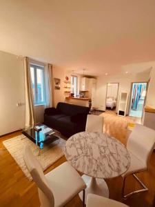 uma sala de estar com uma mesa e cadeiras brancas em Sublime Rooftop Cinq-Avenues Longchamp em Marselha