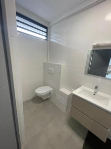 Montjoly的住宿－Le refuge rafraîchissant，白色的浴室设有卫生间和水槽。