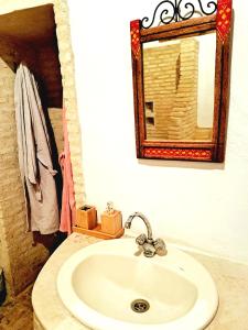 a bathroom with a sink and a mirror at Maison d'hôtes "Dar Khalifa" in Tozeur