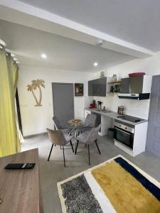 uma cozinha com mesa e cadeiras num quarto em Le refuge rafraîchissant em Montjoly