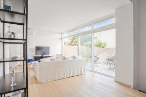 Apartment near the sea in Marseille - Welkeys في مارسيليا: غرفة معيشة مع أريكة بيضاء وباب زجاجي منزلق