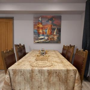 a dining room table with chairs and a painting of sailboats at Charming Jersey Cottage with parking 8 Guests in Cowes