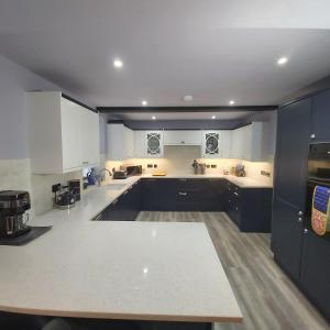 a large kitchen with white cabinets and a table at Charming Jersey Cottage with parking 8 Guests in Cowes