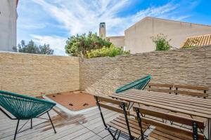 a patio with two chairs and a bench and a brick wall at Modern house near the sea in Marseille - Welkeys in Marseille