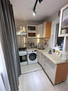 a small kitchen with a sink and a dishwasher at Fresh and cozy apartmrent in Yakkasaray
