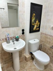 a bathroom with a white toilet and a sink at Fresh and cozy apartmrent in Yakkasaray