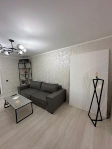 a living room with a couch and a table at Fresh and cozy apartmrent in Yakkasaray