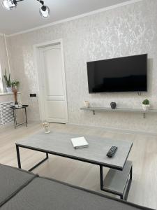 a living room with a flat screen tv on a wall at Fresh and cozy apartmrent in Yakkasaray