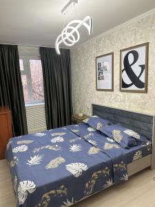 a bedroom with a bed with a blue comforter at Fresh and cozy apartmrent in Yakkasaray