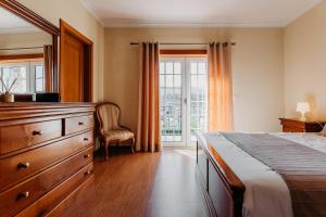 a bedroom with a bed and a dresser and a window at A Nossa Casa in Castelejo