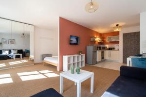 una sala de estar con un sofá y una mesa en Vieux Lille -Nice studio neat and fully equipped !, en Lille