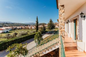 una casa con balcone affacciato su una strada di A Nossa Casa a Castelejo