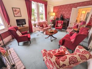 a living room with red chairs and a couch at Foxhills in Shanklin