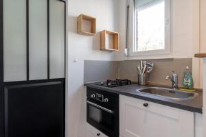 uma cozinha com um lavatório e um fogão em Vieux Lille Bright fully-equipped apartment! em Lille