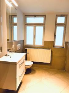 łazienka z toaletą, umywalką i oknami w obiekcie Suite ll für 6 Aalen Netflix WLAN w mieście Aalen
