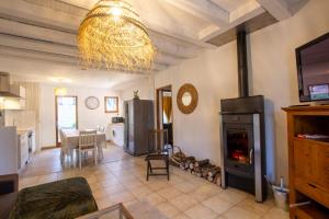a living room with a fireplace and a dining room at Maison conviviale in Nadaillac